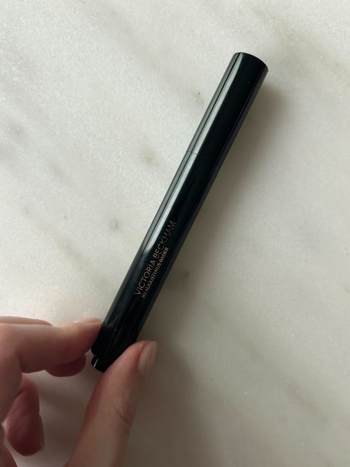 The Victoria Beckham concealer on a white marble background