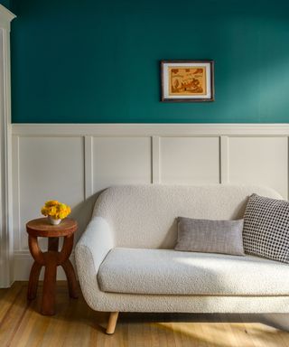 room with teal walls above wainscot paneling