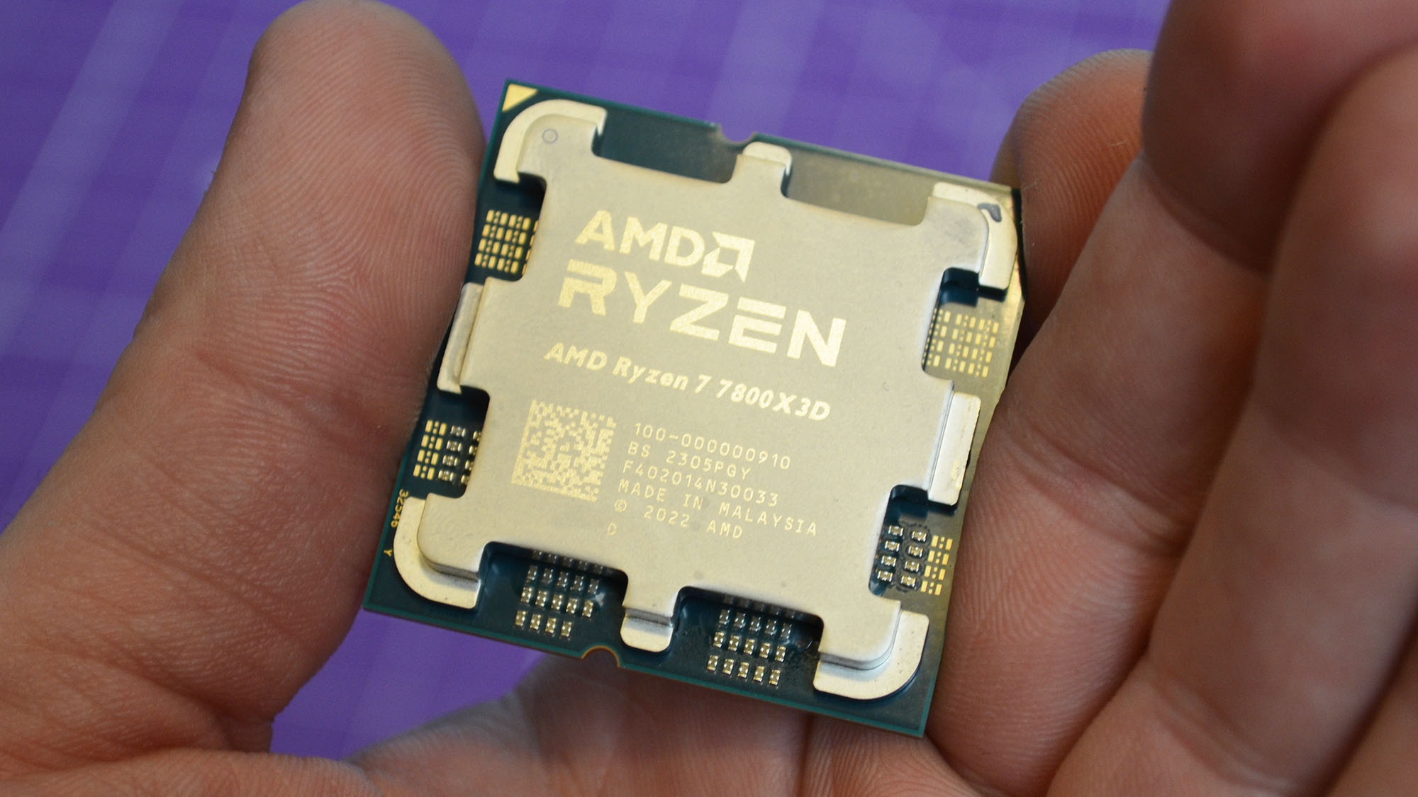 An AMD Ryzen 7 7800X3D in a man's hand
