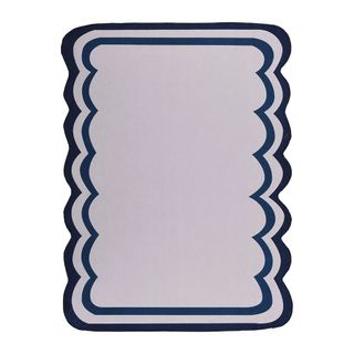 Daals scalloped edge rug with navy blue trim.