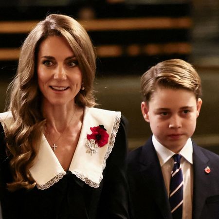 Princess Kate wears a giant white pilgrim collar with a black dress and a red poppy, and her son Prince George wears a black suit