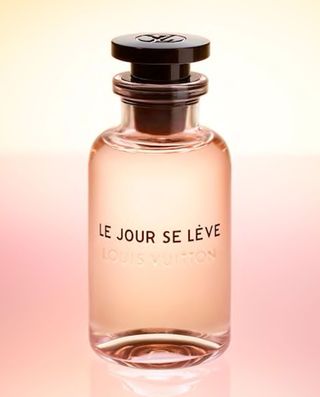 Bottle of le jour se leve perfume against a light pink background