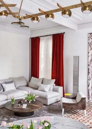 White living room with red curtains