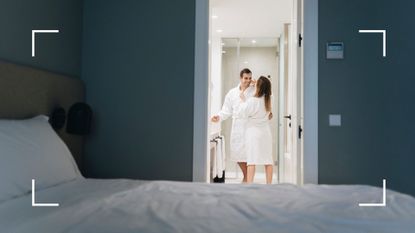 Couple dressed in white bath robes, laughing and coming out of the bathroom in a hotel after having sex in the shower
