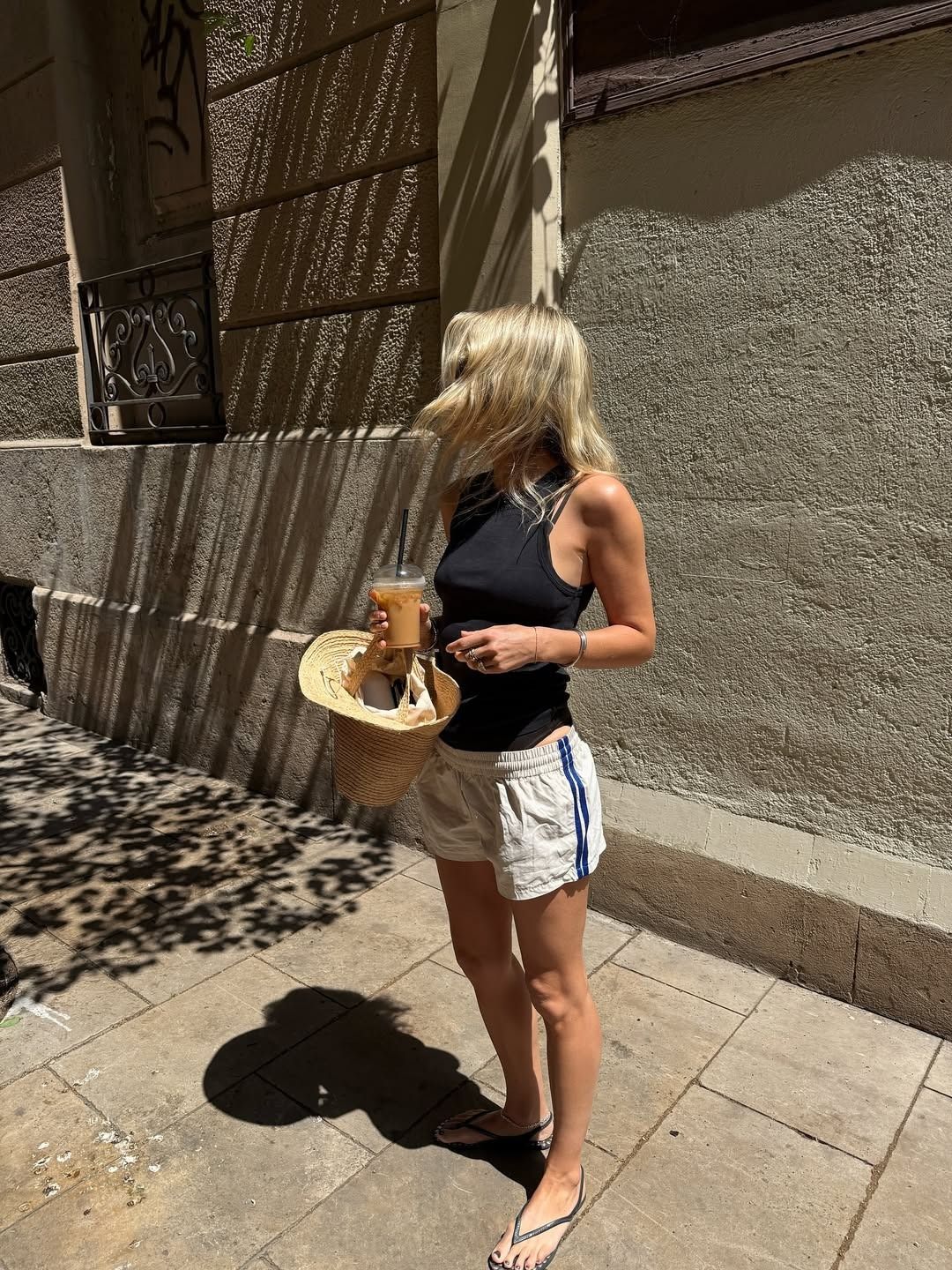 Woman in black tank top and sporty shorts