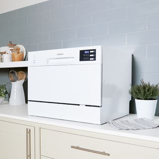 white countertop dishwasher with drawers and potted plant
