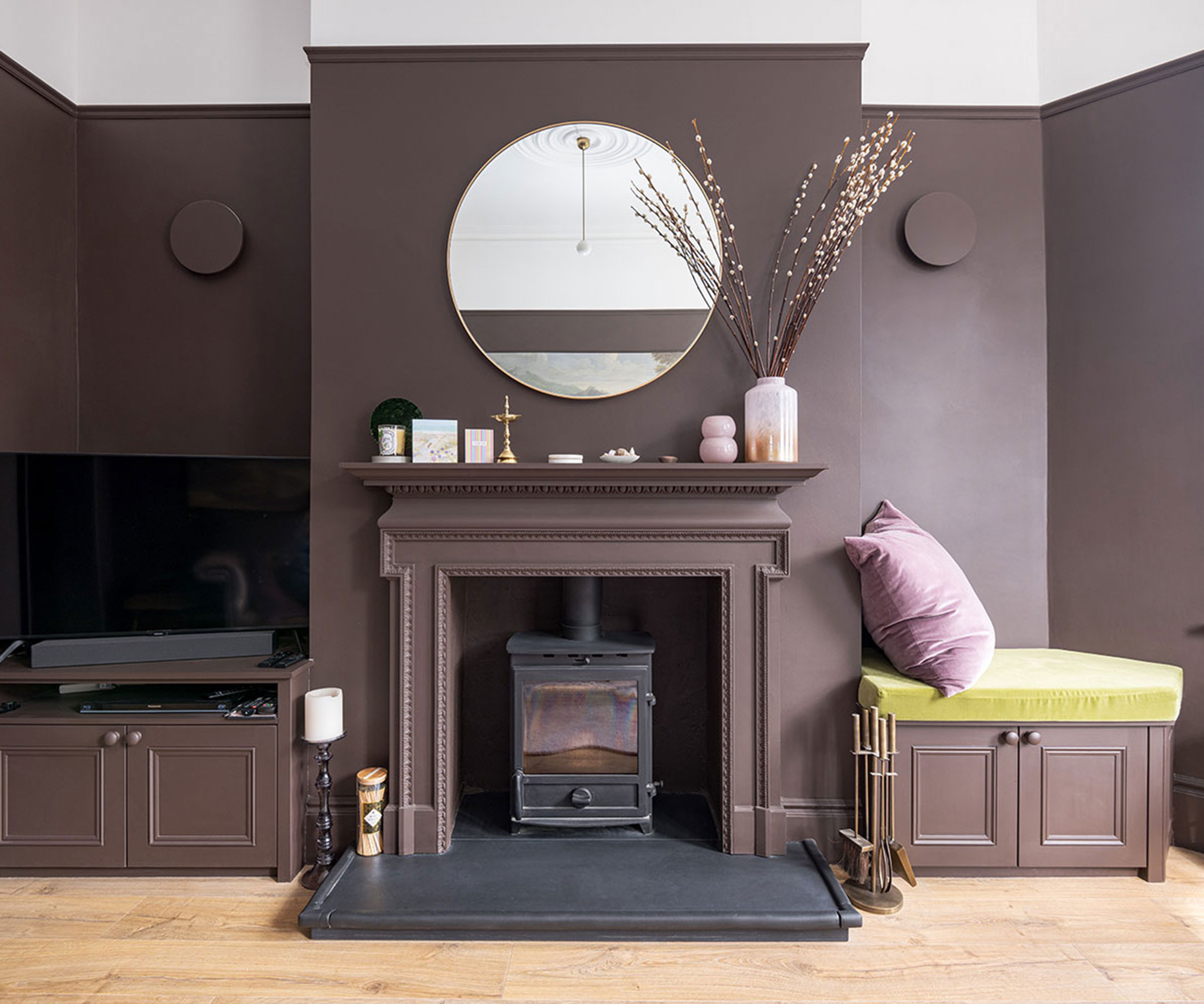 brown colour drenched room with log burner and built in alcove seating