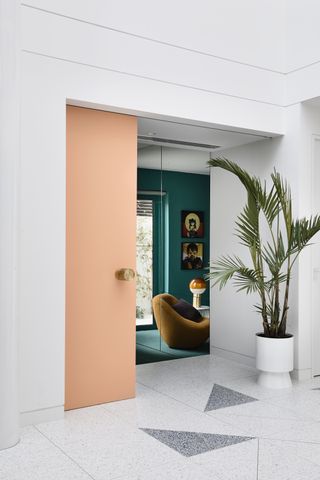 A passageway with a peach door and emerald green interior