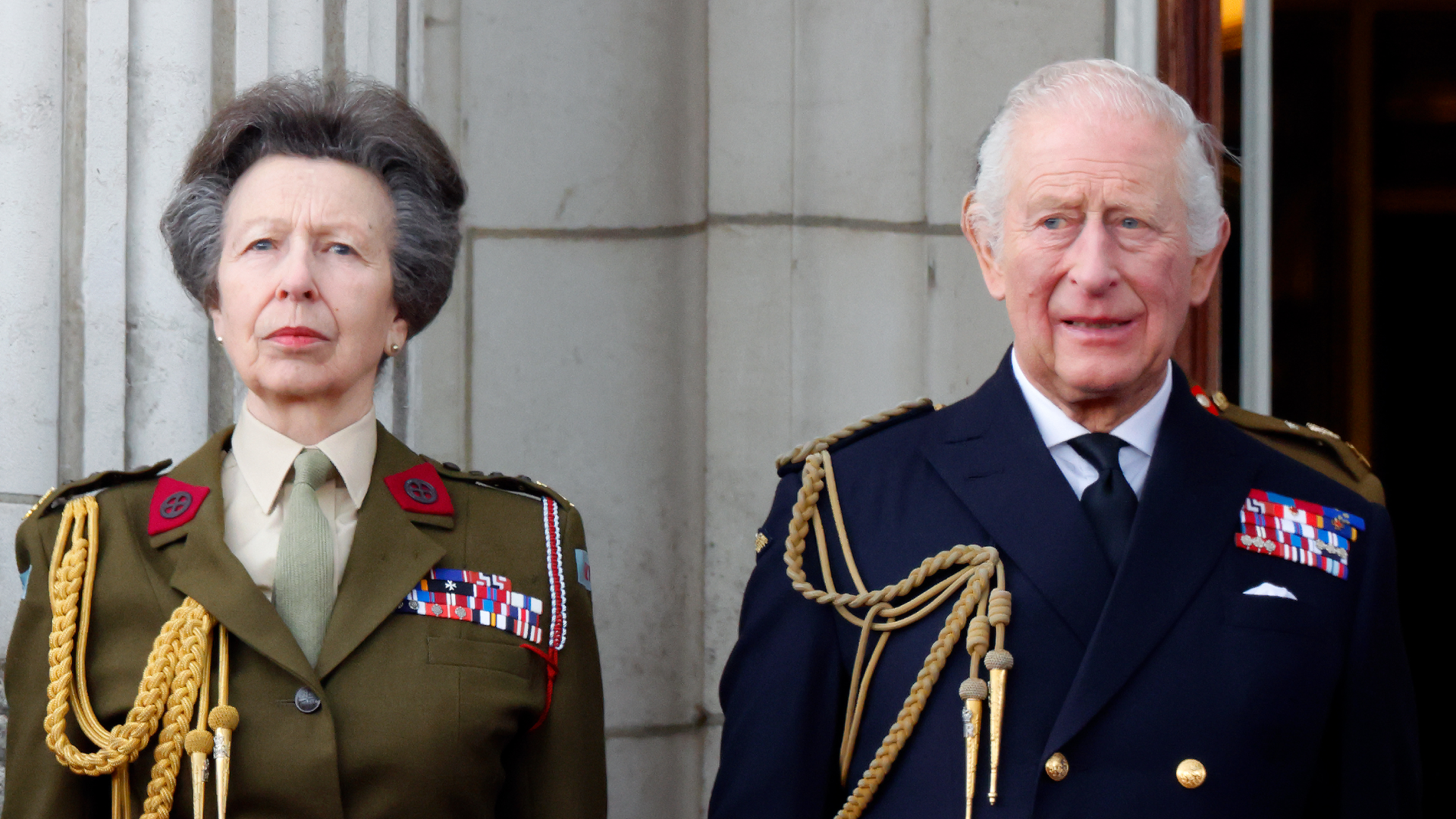 Princess Anne standing next to King Charles in military uniforms