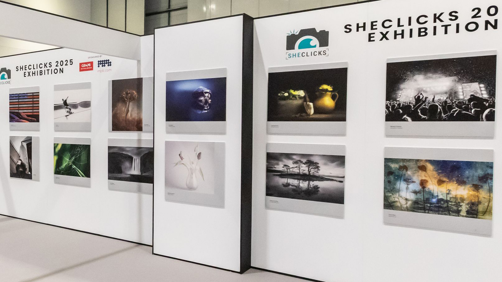 Wall display featuring diverse photographs at the SheClicks 2025 Exhibition, highlighting various artistic themes and styles
