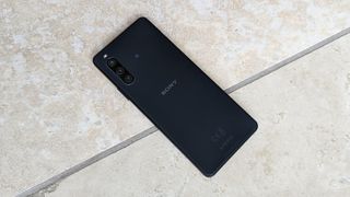 The Sony Xperia 10 IV in black face down on a tiled floor