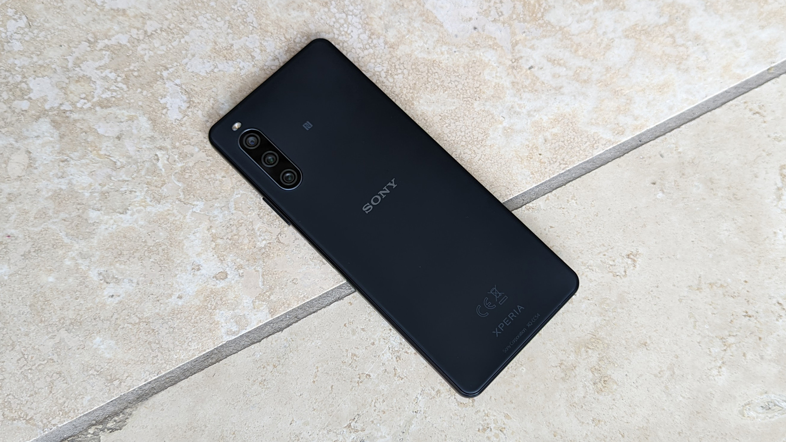 The Sony Xperia 10 IV in black face down on a tiled floor