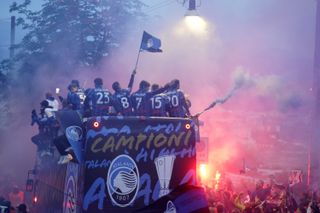 Atalanta's players and staff celebrate the club's Europa League final win over Bayer Leverkusen in a bus parade through Bergamo in May 2024.