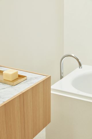 Honed Carrara marble and oak joinery, with Vola tapware from Denmark