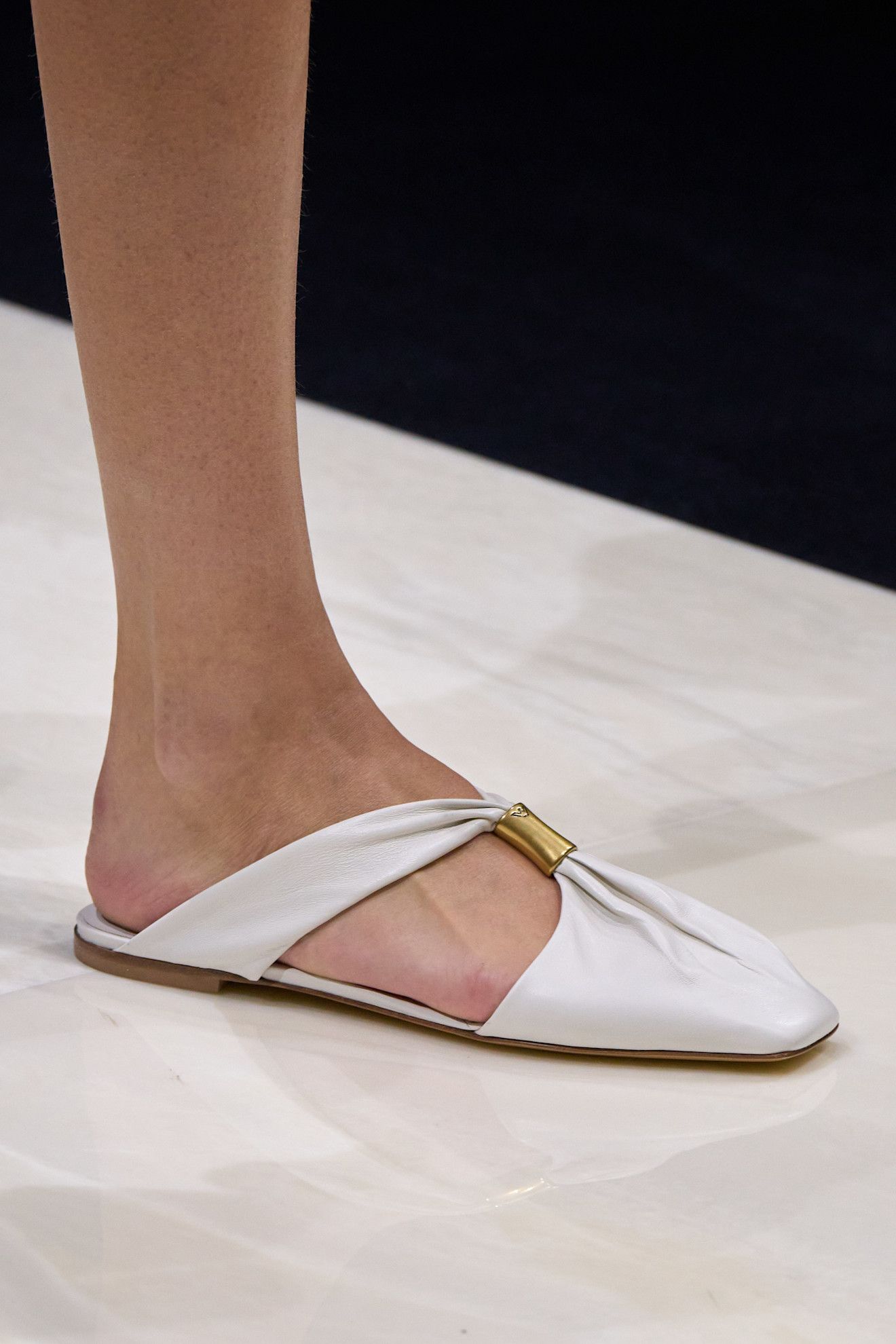 Summer Shoe Trends 2025: A model wears shoes with gold hardware on the Emporio Armani spring/summer 2025 runway