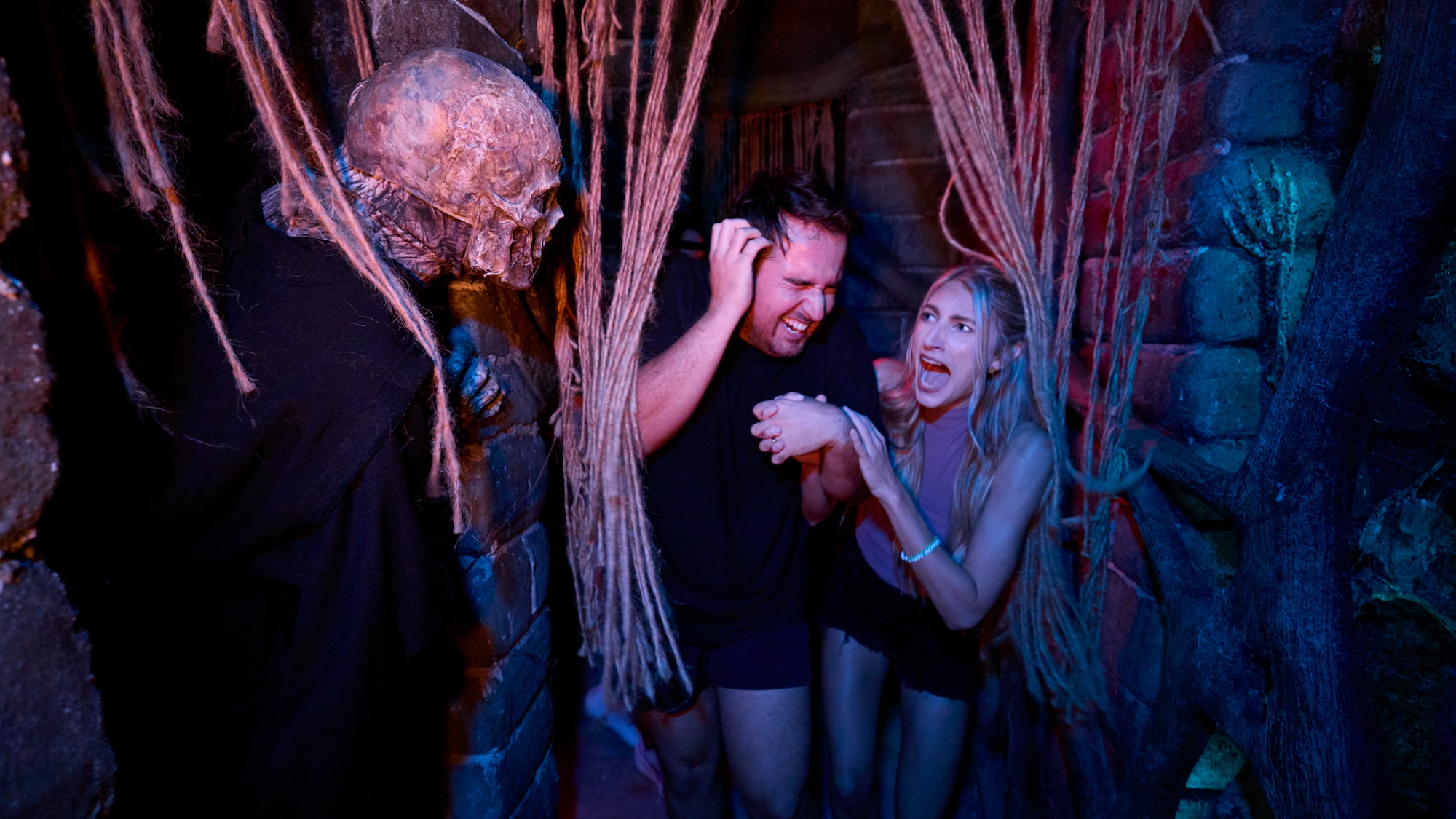 two guests getting scared while in haunted house at Universal Studios HHN