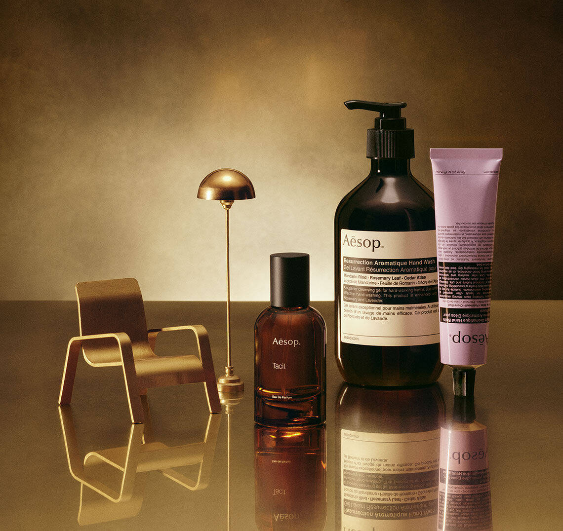 aesop products on reflective gold surface