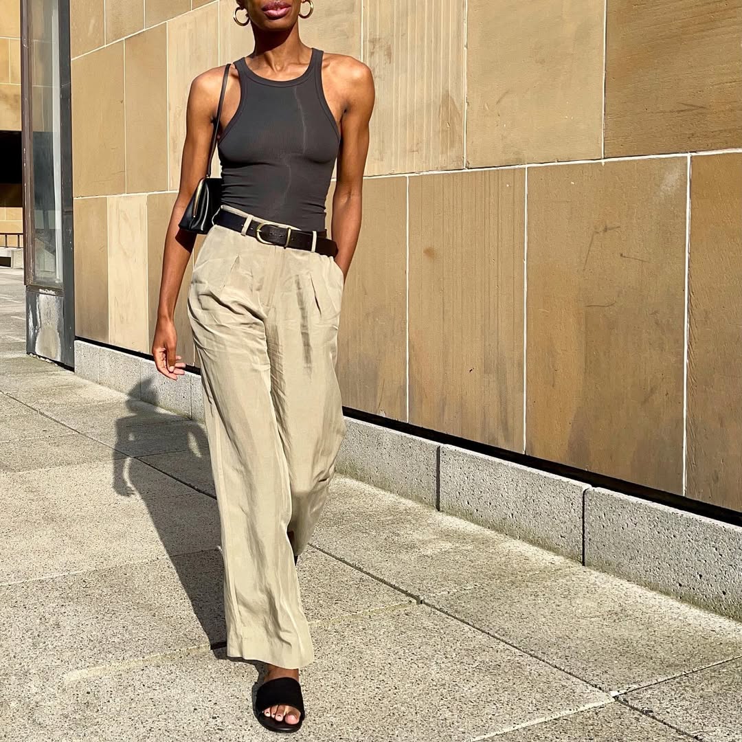 woman wearing black tank, trousers, and black leather belt