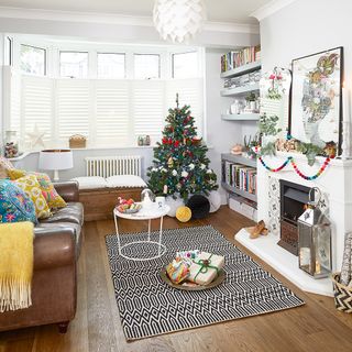 living room with christmas tree near book shelf
