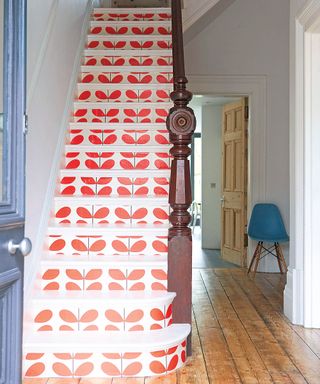 white wall corridor with stairs with red leaf wallpaper and wooden floor