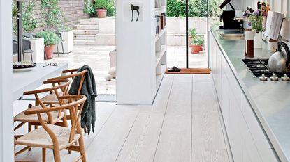 white kitchen with steel worktops and garden beyond