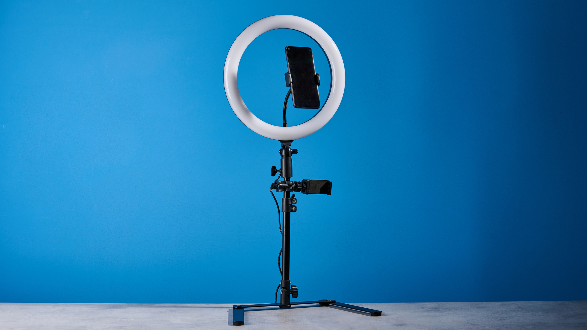 Godox 12-inch ring light photographed in front of a blue background with an iPhone on the phone mount.