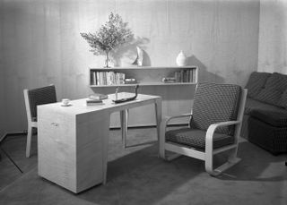 Small wooden desk with two chairs photographed in black and white