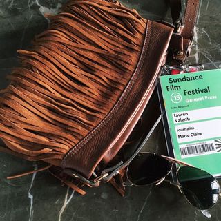 Sundance Film Festival badge, brown purse and sunglasses