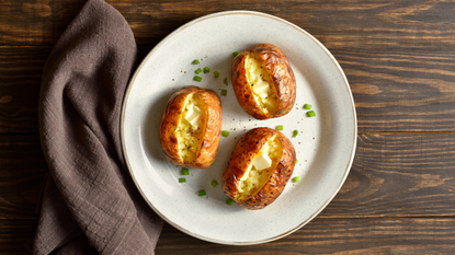 Baked potatoes with butter on a white plate.