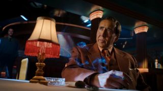 Nicolas Cage looking forward at a table in Spider-Noir.