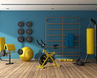 A home gym with blue wall decor and yellow gym equipment