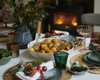 dining table with festive green plates, colored glassware and jute placemats