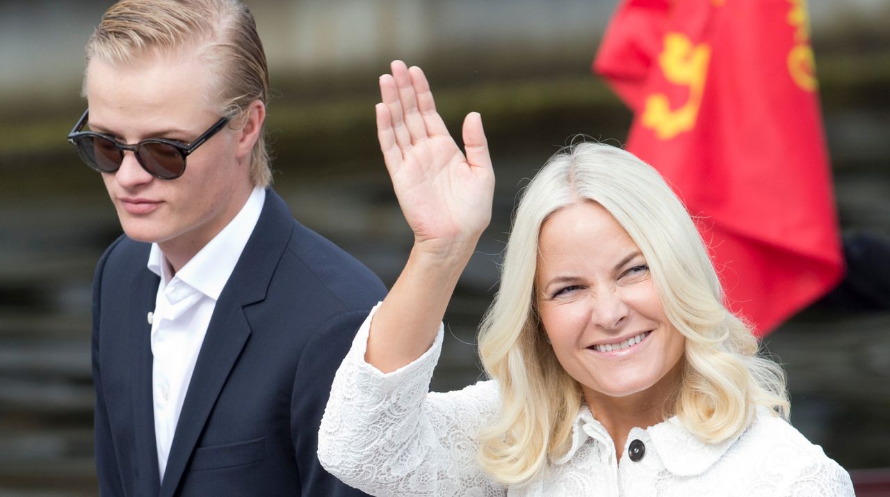 Marius Borg Hoiby wears sunglasses and has slicked back blond hair, and his mother, Crown Princess of Norway Mette-Marit, wears a white jacket, has blonde hair, and waves