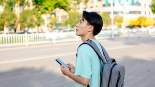 A man calls a taxi with his smartphone on the road.