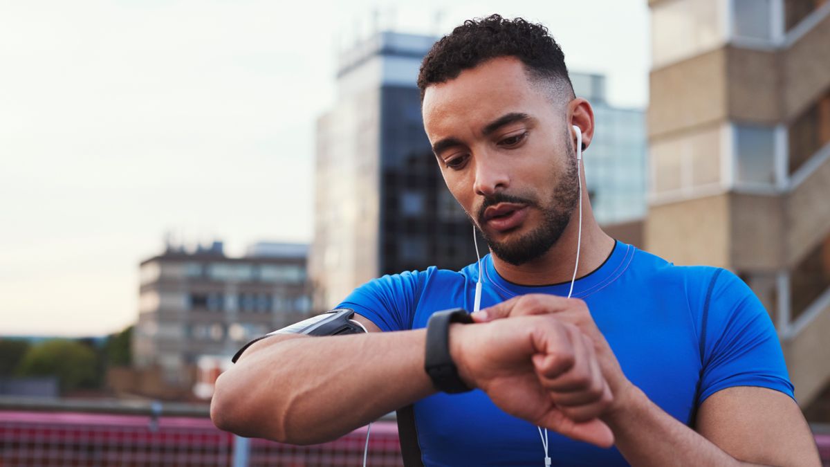 Man checking stats on his sports watch during workout