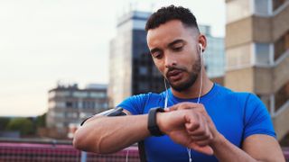 Man checking stats on his sports watch during workout