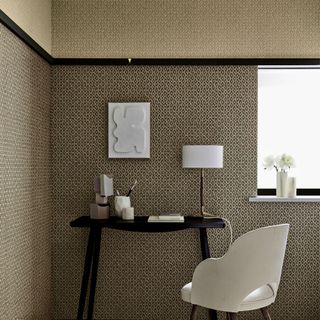 a black desk and white chair against a wall papered in the same wallpaper but in different shades separated by a black picture rail