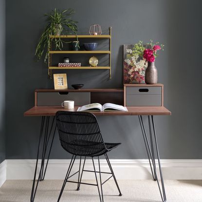 home office room with grey wall and wooden desk with black chair