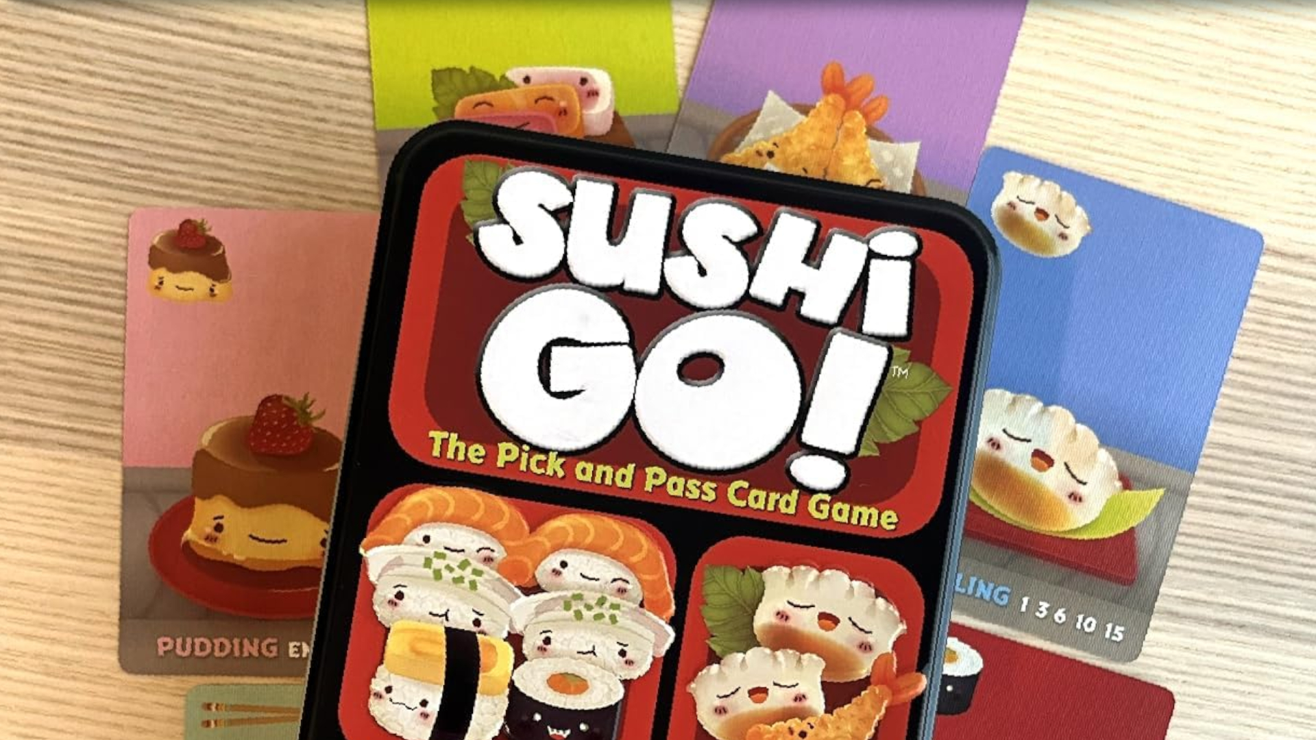 Sushi Go tin and cards laid out on a wooden table