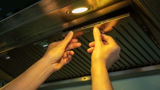 woman taking out her extractor fan filter