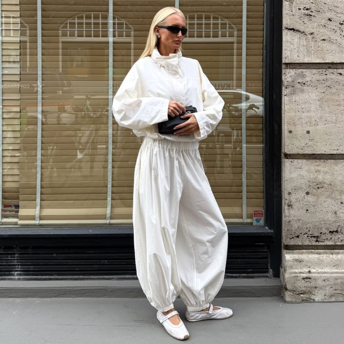 lovisa worge wears a white funnel neck jacket and matching balloon trousers