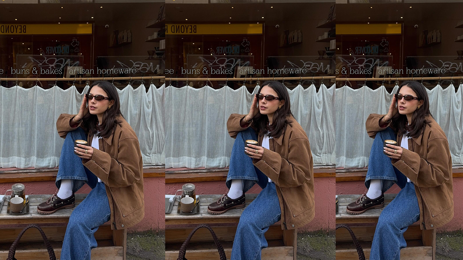 tia drinks coffee at cafe while wearing blue jeans, brown loafers and a suede jacket