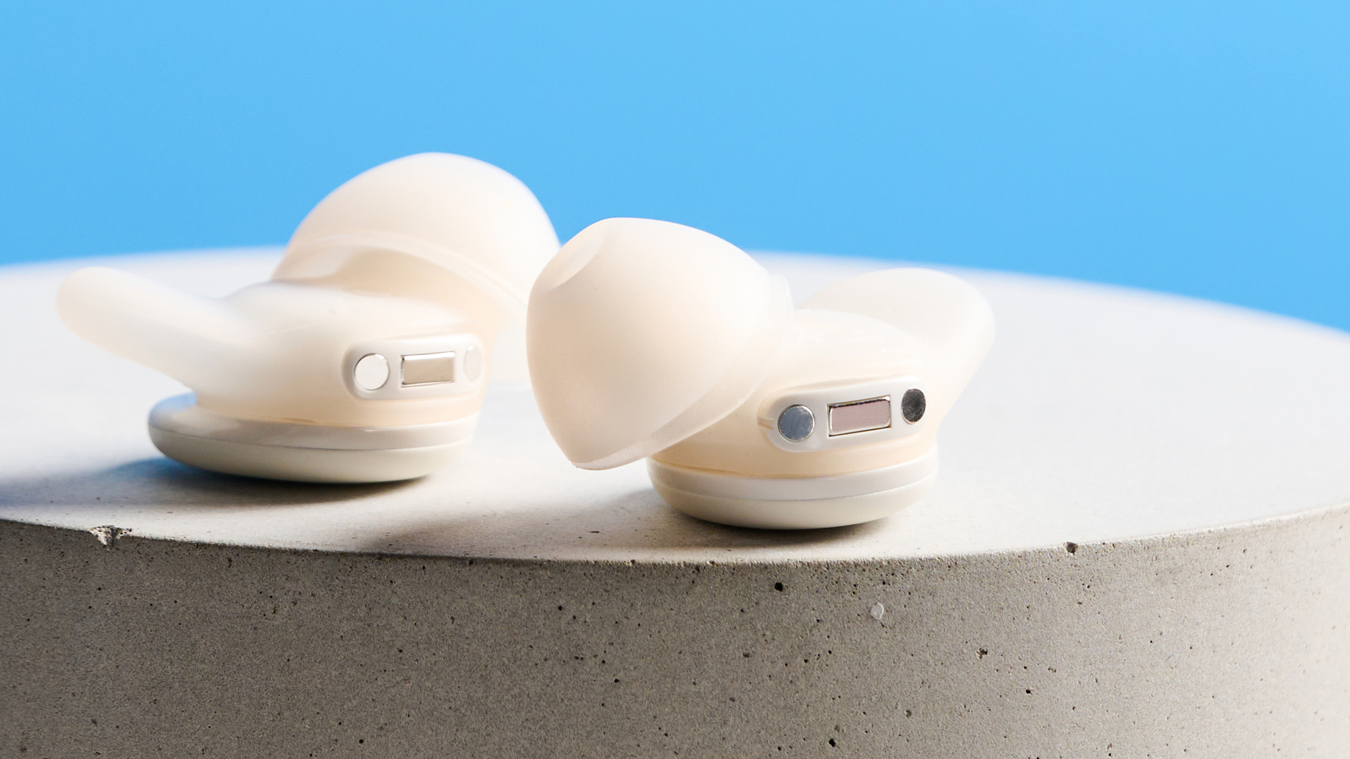 The Soundcore Sleep A30 earbuds on a stone plinth against a blue background