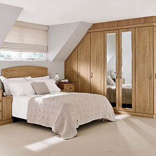 bedroom with wooden wardrobe and sloping ceiling