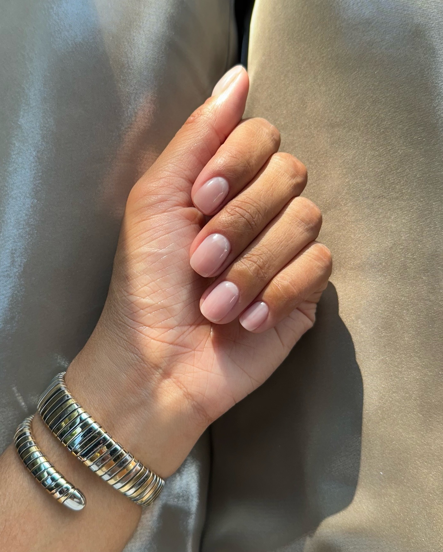 A picture of a women's hand with a short, natural-looking manicure