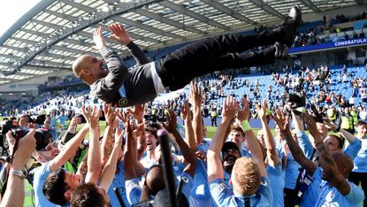 Manchester City players throw Pep Guardiola in the air after their Premier League title win 