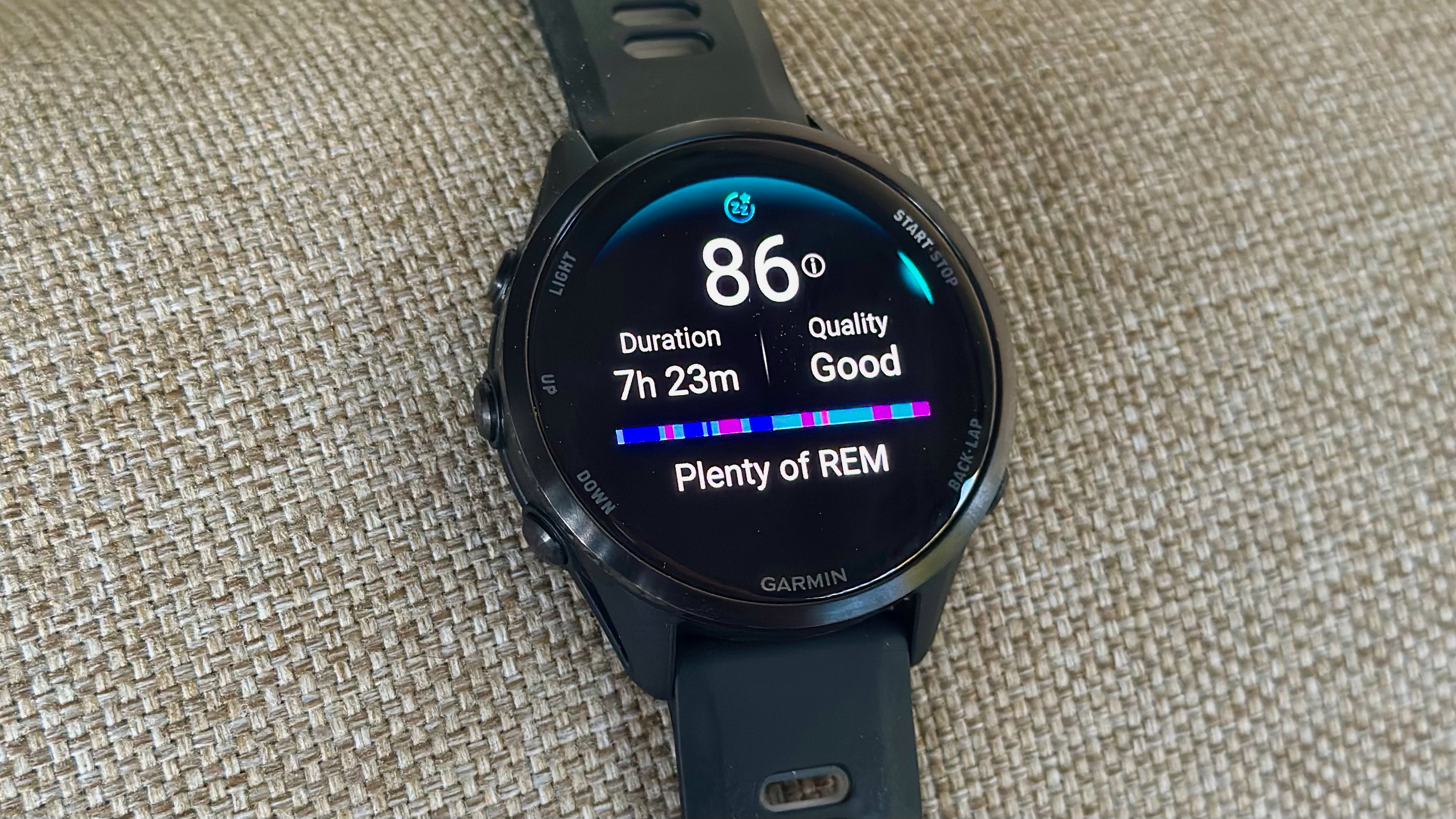 The Garmin Forerunner 970 showing a sleep summary, with the Sleep Score, Duration, Quality, a timeline of sleep zones, and "Plenty of REM" summary