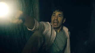 Justin Long holds a flashlight in Barbarian