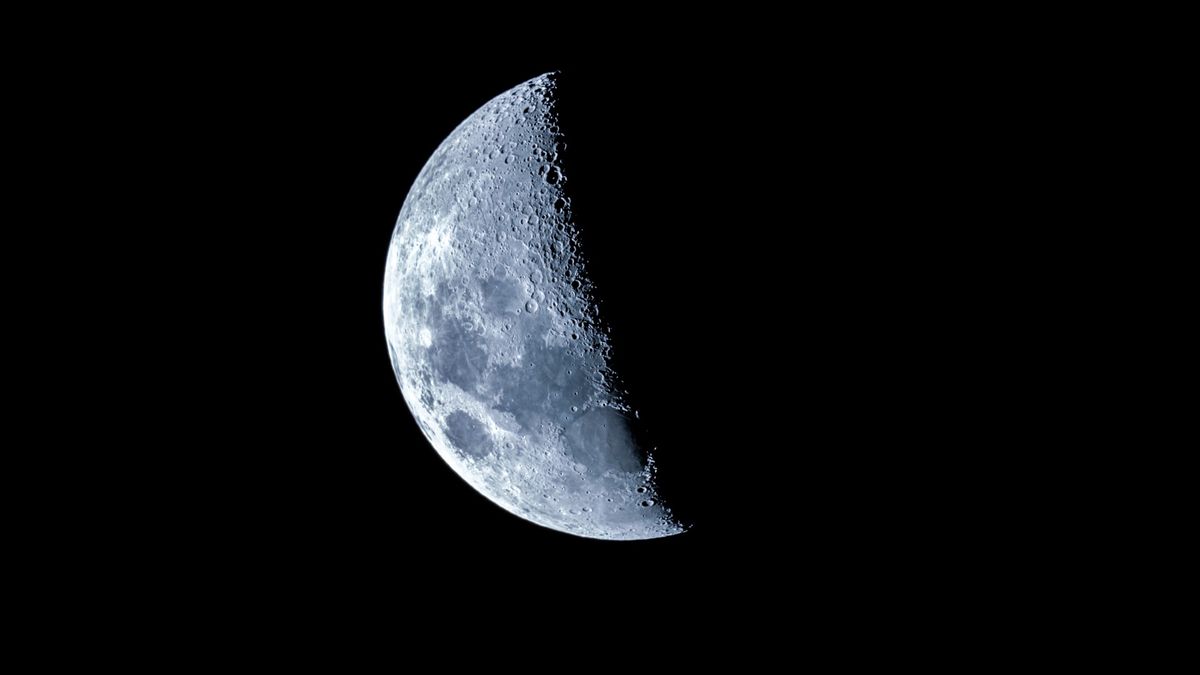 a half-lit moon in the night sky