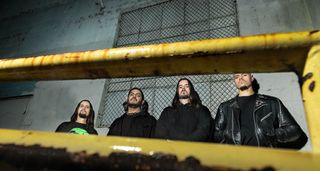 A portrait of California hardcore band Nails with their new 2024 lineup, photographed in an urban setting, framed by yellow hand rails.